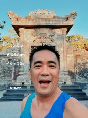 Thuận trong áo xanh trước cổng đá sau buổi chạy